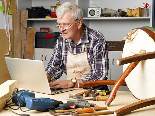 Woodworker fixing a broken chair in his garage>